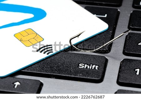 Close up fishing hook, credit card and mouse on computer keyboard. phishing and cyber crime concept. For copy space.