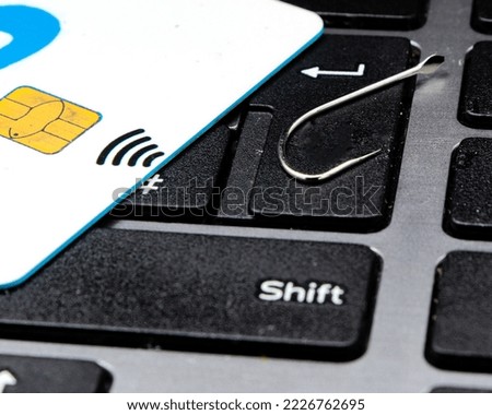 Close up fishing hook, credit card and mouse on computer keyboard. phishing and cyber crime concept. For copy space.
