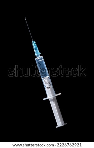 Medical disposable two cc syringe with a needle filled with liquid. Plastic syringe with medicine, drugs or vaccine, isolated on black background. Creative Coronavirus or 2019-nCoV or COVID-19 vaccine Royalty-Free Stock Photo #2226762921