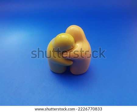 Interior decoration made of ceramic with hugging character on a blue background