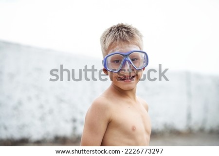 Teenager in swimming goggles enjoys summer holidays on beach