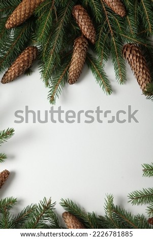 Christmas background with festive decoration and toys.On white wood surface. Holidays greeting card or banner composition with pine tree branches. Merry Christmas background and Happy New Year 2023.
