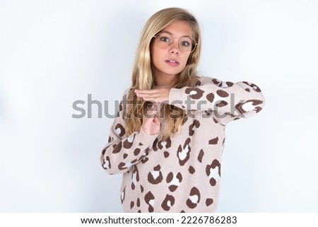 caucasian teen girl wearing animal print sweater over white background feels tired and bored, making a timeout gesture, needs to stop because of work stress, time concept.