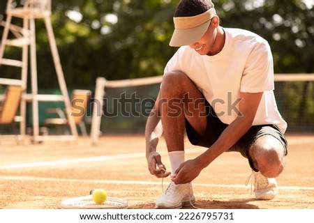 Man in sun visor at the tennis courts before workout Royalty-Free Stock Photo #2226795731
