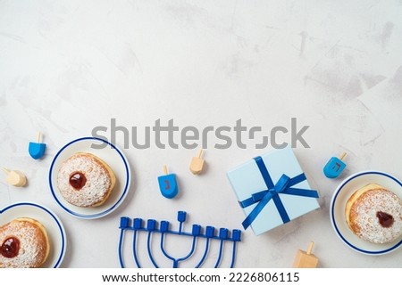 Background with traditional sweet donuts, menorah and gift box.  Hanukkah holiday concept. Top view, flat lay