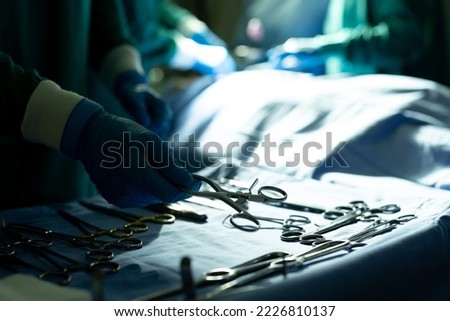 Hands of surgical tech picking up instrument for surgeon in operating theatre, with copy space. Hospital, medical and healthcare services.