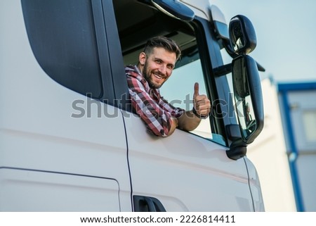 Truck driver sitting in his truck showing thumbs up. Trucker occupation. transportation services. Royalty-Free Stock Photo #2226814411