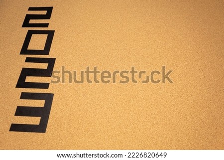 A blank cork board with the number 2023 vertically on the left side with copy space