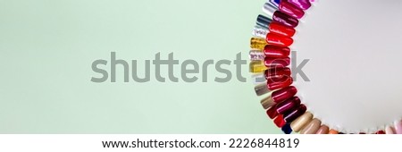 web banner for nail studio.Nail polish samples in different bright colors. Colorful nail lacquer manicure swatches. Top view of nail art wheel palette.
