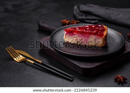 Homemade tasty cheesecake with jelly and raspberry berries on a black plate on a dark concrete background Royalty-Free Stock Photo #2226845239