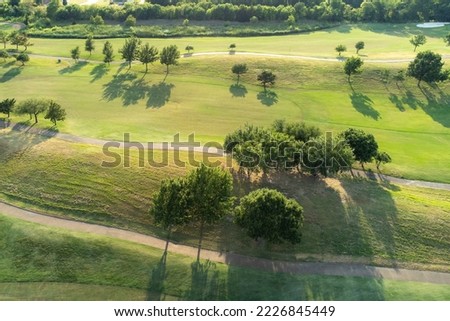 Top aerial view of beautiful park, green zone. Birds eye and drone photography of summer park. Nature landscape, green meadows in countryside in sunny day.
