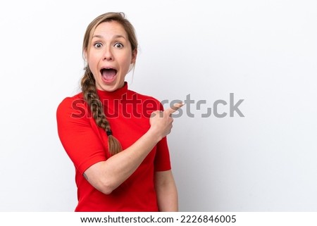 Young caucasian woman isolated on white background surprised and pointing side