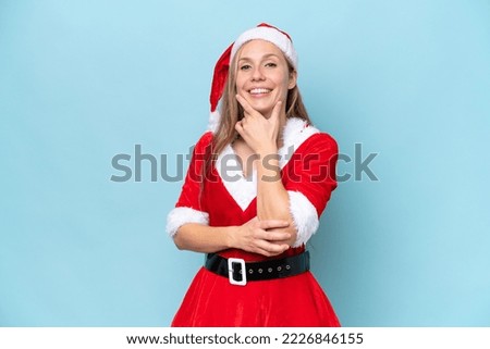 Young blonde woman dressed as mama claus isolated on blue background smiling