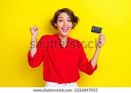Photo of young funny excited positive good mood businesswoman hold bank card fist up crazy screaming isolated on bright yellow color background