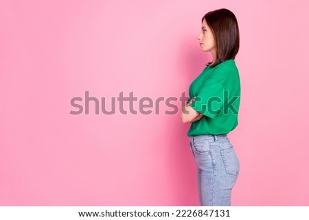 Profile photo portrait of pretty young lady look empty space folded arms strict wear stylish green outfit isolated on pink color background