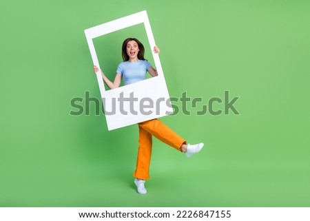 Full length portrait of crazy cheerful person hands hold big paper album card isolated on green color background