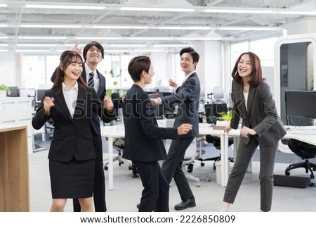 asian businesspeople dancing in the office