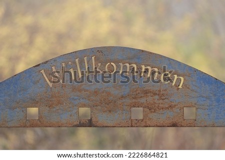 old rusty sign board willkommen (welcome) 
