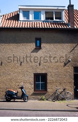 Bike and scooter against brick facade