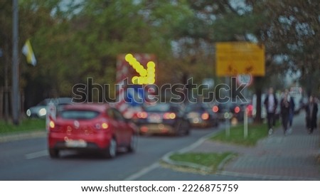 Blurred Roadworks Lane Arrow Caution Warning Sign with Orange Pulsing Lights