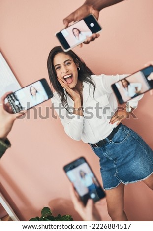 Its important to find the perfect selfie. Shot of a beautiful young woman having her picture taken on multiple phones.