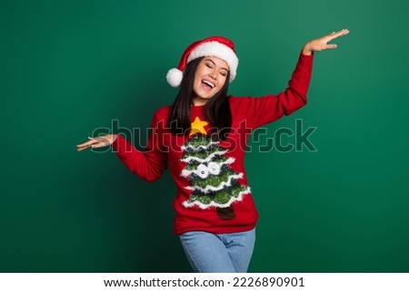 Photo of pretty cute relaxed japanese woman raise hands up active motion dancing xmas music wear ugly sweater isolated on green color background