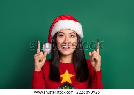 Portrait of positive cheerful woman with long hairdo wear red sweater directing look empty space isolated on green color background