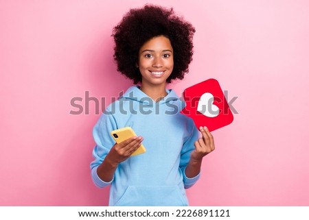 Photo portrait of charming girl hold gadget social media heart notification dressed stylish blue look isolated on pink color background