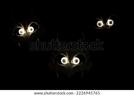 Scary bone monster mask made of silicon photographed with glowing monster eyes on black background hand made and designed by photographer Thailand Asia