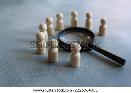 Wooden dolls and magnifying glass. Brainstorm, meeting, investigate, looking for solution concept Royalty-Free Stock Photo #2226964355