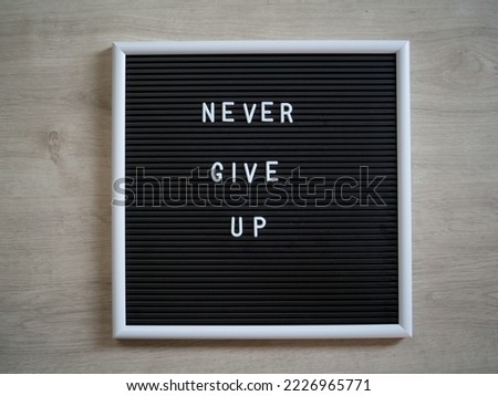 Never give up  letters and words spelled out on a board - motivational quote