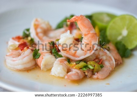 Fresh shrimp on white plate and fresh vegetables, cooked shrimps prawns and seafood spicy chili sauce coriander, cooking shrimp salad lemon lime Royalty-Free Stock Photo #2226997385