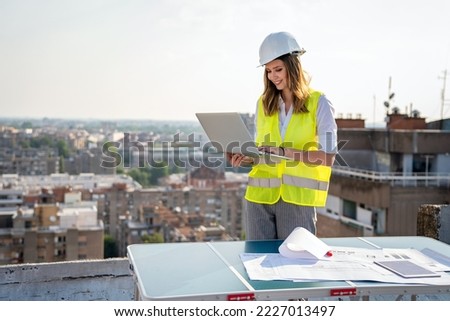 Portrait of engineer businesswoman at construction site. Female architect with blueprint.