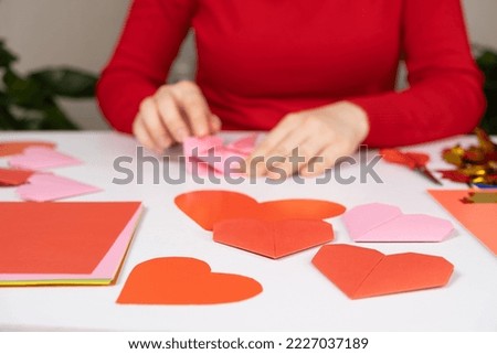 Making origami hearts for Valentine's Day. Crafts made of paper with your own hands.