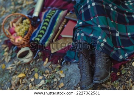 Close up autumn picnic concept photo. Delicious fruits. Hot beverage. Side view photography with pile of books on background. High quality picture for wallpaper, travel blog, magazine, article