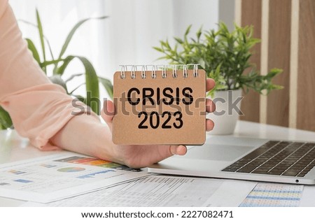 CRISIS text in an office notebook on a wooden table.