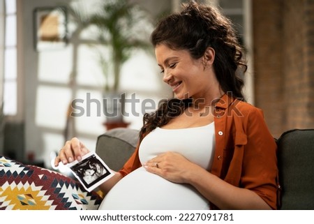 Pregnant woman with ultrasound photo. Beautiful pregnant woman enjoy at home	
