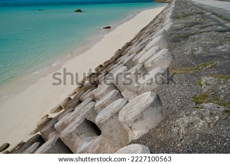 Concrete round levee and small white sand beach Royalty-Free Stock Photo #2227100563