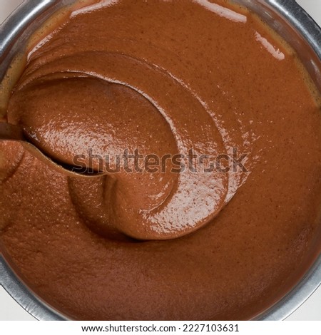 chocolate caramel cream, beating with a spoon, oil cake mixture closeup, taken straight from above isolated on white, food background Royalty-Free Stock Photo #2227103631