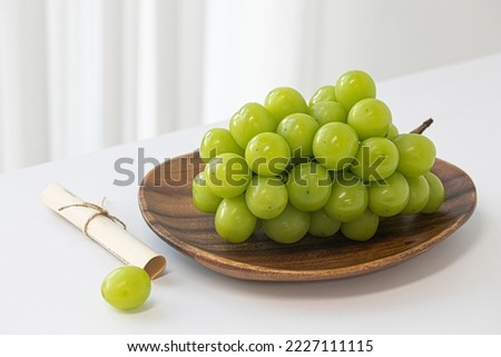 Shine Muscat grapes on a white background. White grapes. Royalty-Free Stock Photo #2227111115