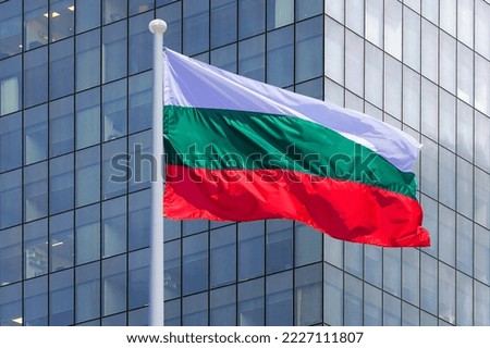 Waving in the wind flag Bulgaria on the background of a modern building. Concept of politics, business and tourism in Bulgaria