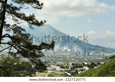 Picturesque view of trees, buildings and mountains under beautiful sky in city