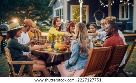 Family and Multiethnic Diverse Friends Gathering Together at a Garden Table. People Eating Grilled and Fresh Vegetables, Sharing Tasty Salads for a Big Family Celebration with Relatives. Royalty-Free Stock Photo #2227127751