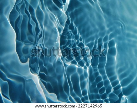 Blur​ abstract​ of​ surface​ blue​ water. Abstract​ of​ surface​ blue​ water​ reflected​ with​ sunlight​ for​ background. Blue​ sea or Blue​ water.​ Water​ splashed​ use​ for​ graphic​ design. Water​