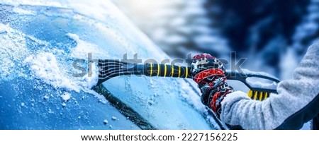 Clearing and remove snow from windshield, Scraping ice. Winter season car window cleaning. Copy space for your text. Panoramatic banner. Royalty-Free Stock Photo #2227156225