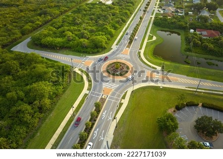 Aerial view of road roundabout intersection with moving cars traffic. Rural circular transportation crossroads Royalty-Free Stock Photo #2227171039