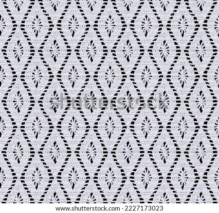 Snow white seamless knitted texture. Beautiful vertical pattern crocheted. Cotton yarn. Lace on a black background.