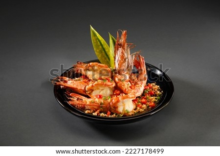 Roasted prawn with chili,garlic and salt in black plate on grey background. Royalty-Free Stock Photo #2227178499
