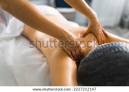 Stress reducing massage. Relaxing back massage performed by professional unrecognizable caucasian massage therapist. Blurred background. High quality photo