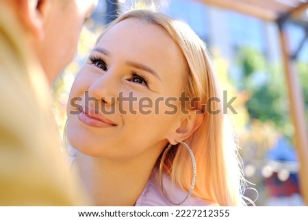 A couple's date. A young woman looks at a man with loving eyes. Horizontal photo